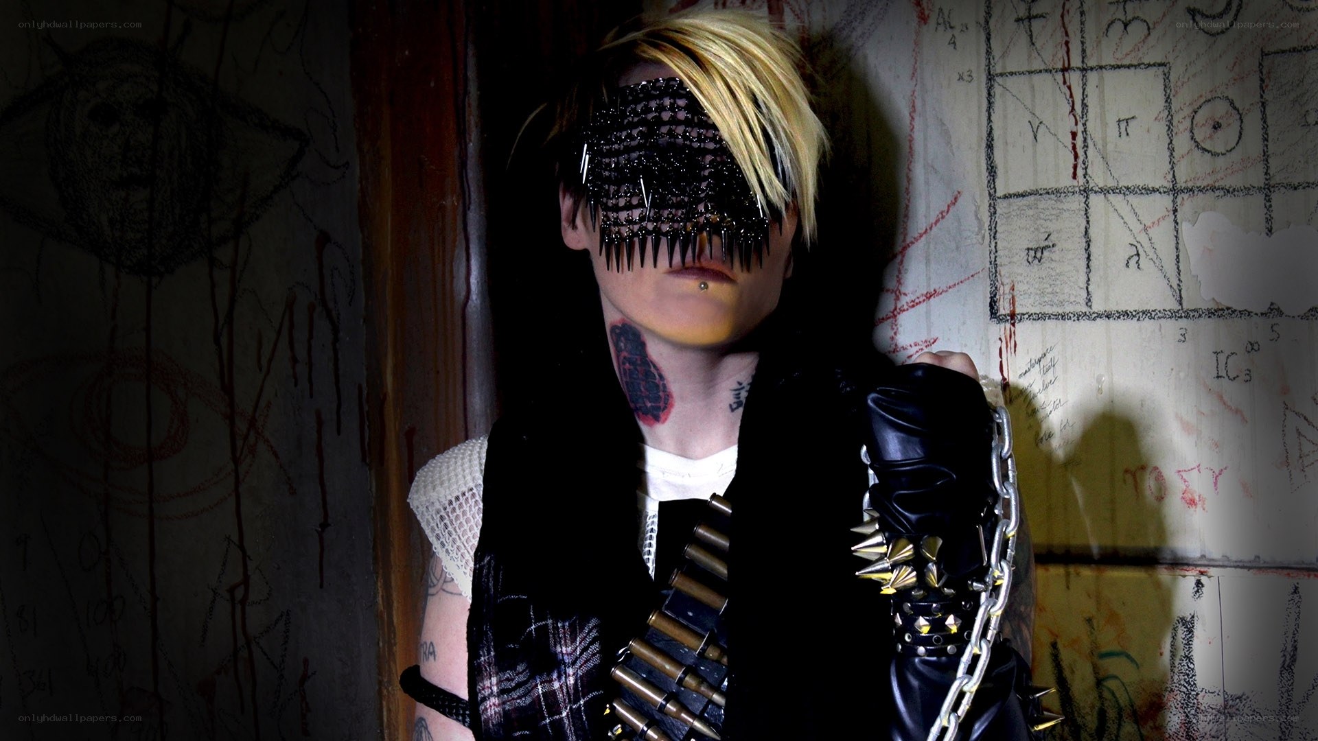 person with spiked mask and tattoos