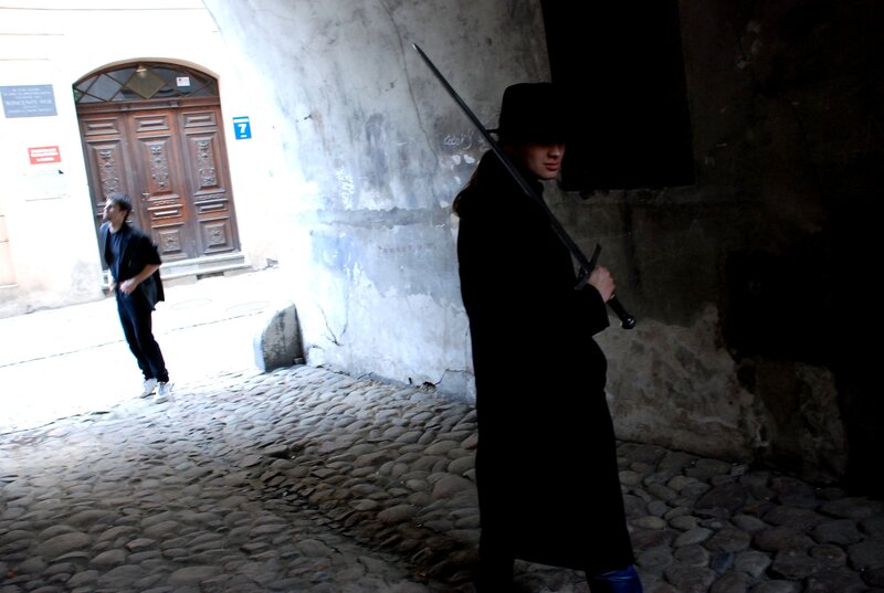Person with sword in alley