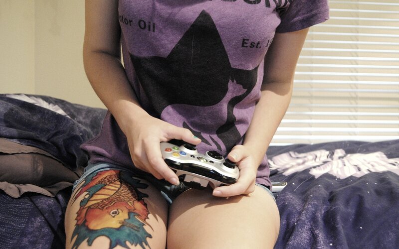 Person with Tattoo Holding Controller