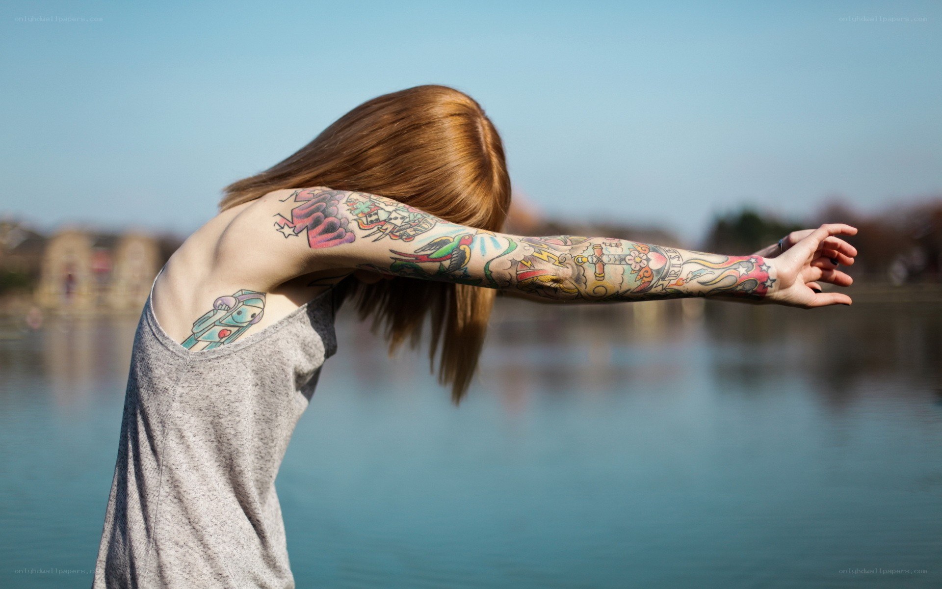 Person with tattoos by the water