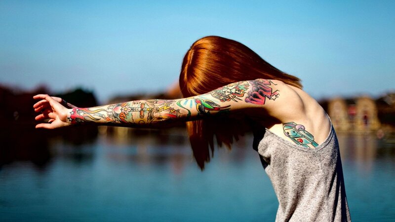 person with tattoos by water