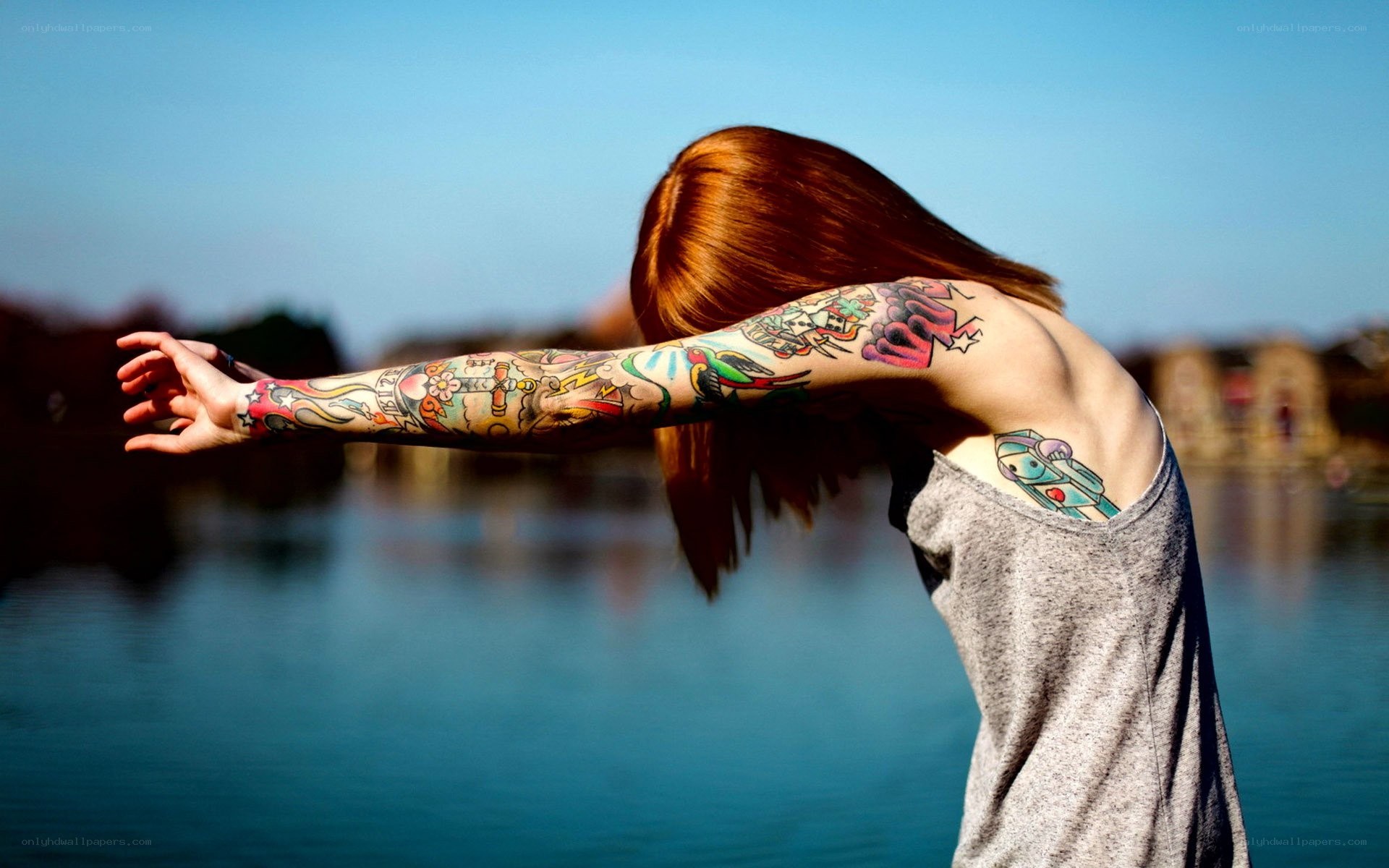 person with tattoos by water