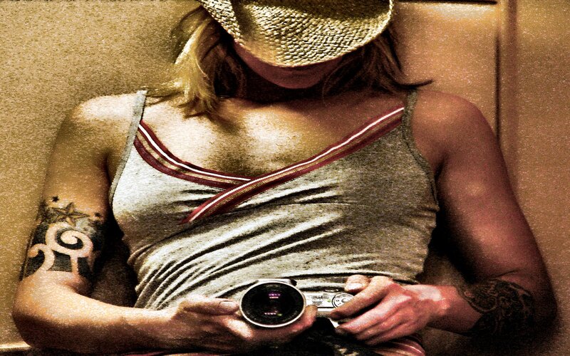 Person with Tattoos Holding Camera — Brown