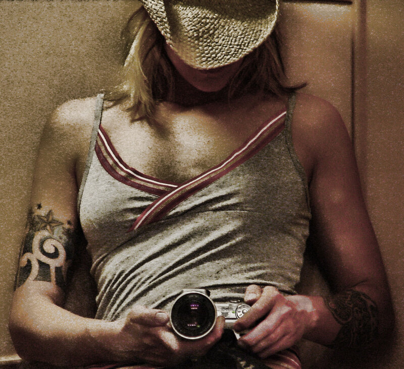 Person with Tattoos Holding Camera