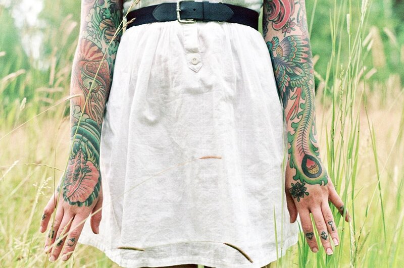 person with tattoos in a field