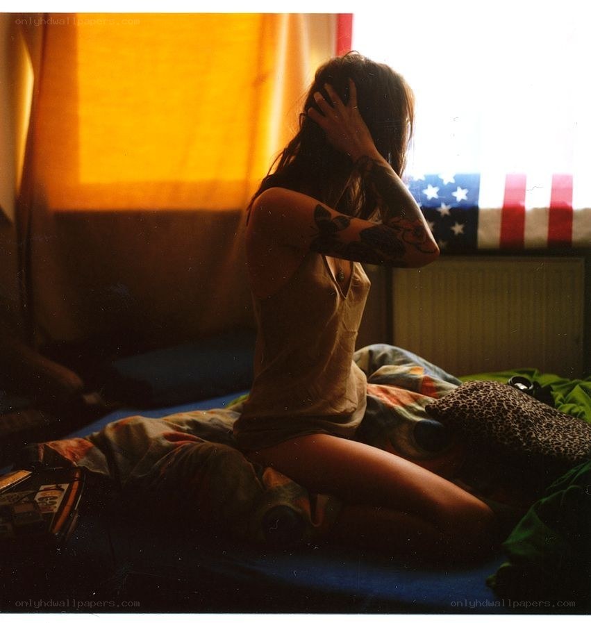 person with tattoos on bed