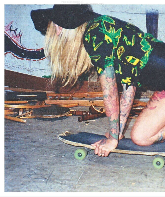 person with tattoos on skateboard