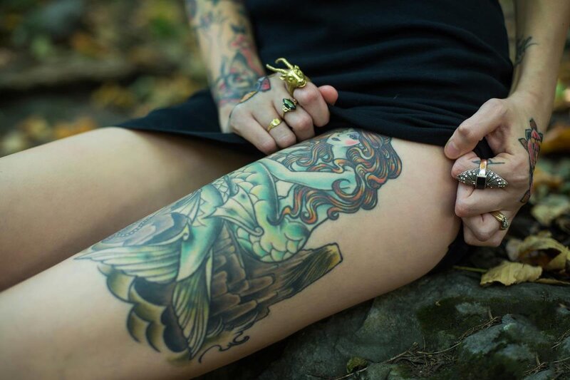 person with tattoos sitting outdoors