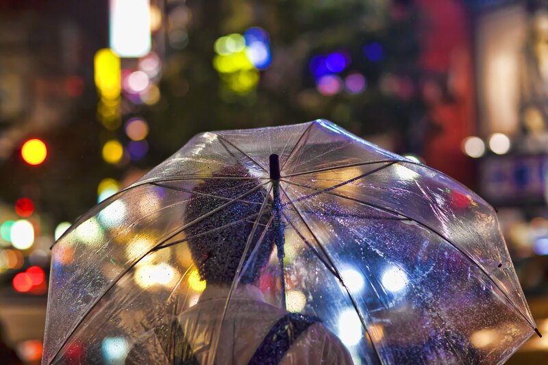 person with transparent umbrella at night