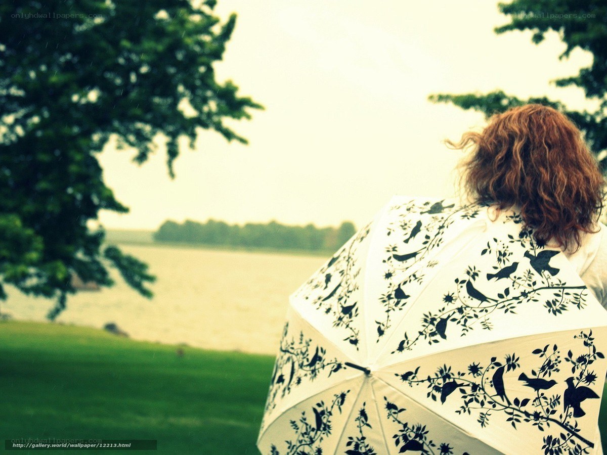 person with umbrella by lake
