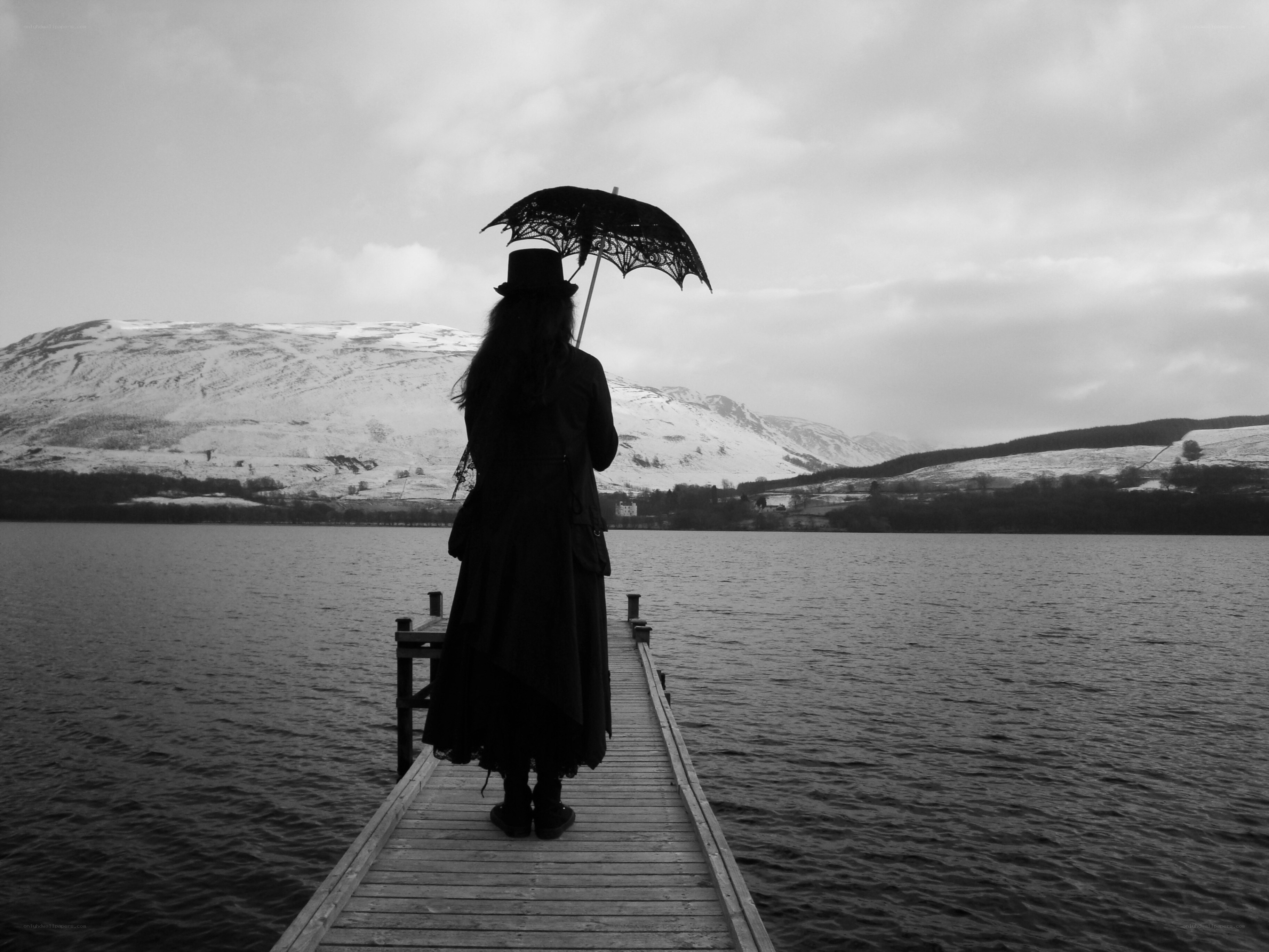 Person with umbrella on dock