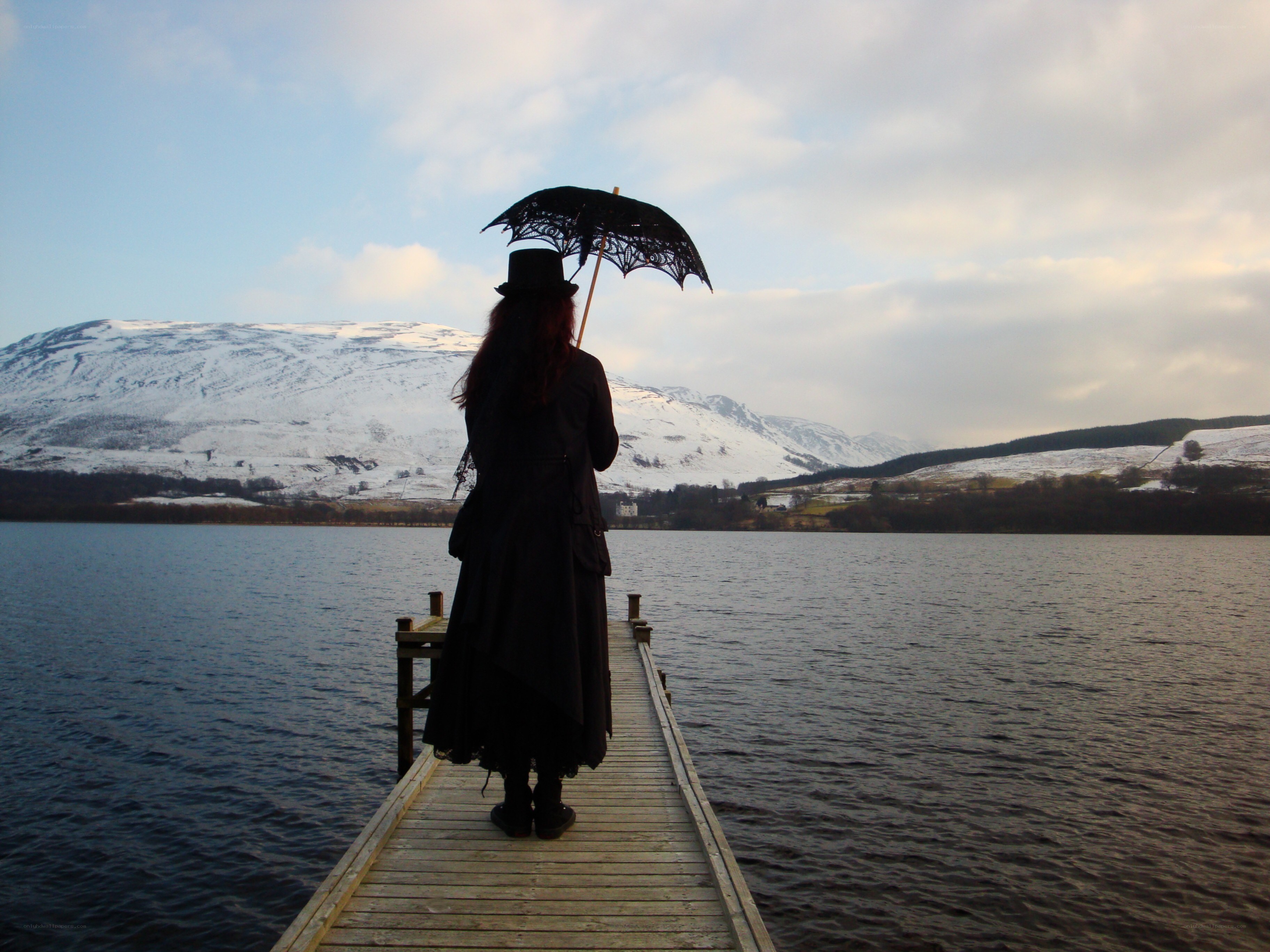 Person with umbrella on dock