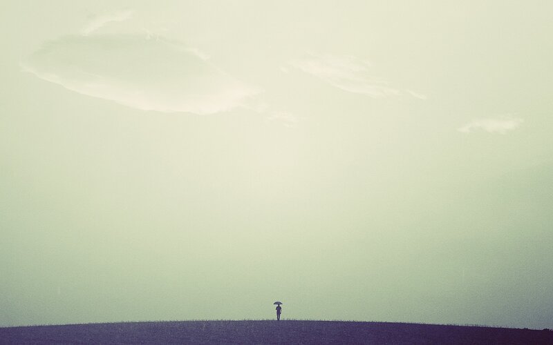Person with umbrella on hill