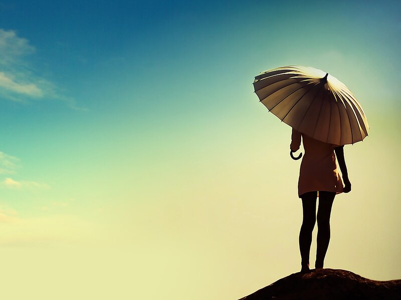person with umbrella on hill