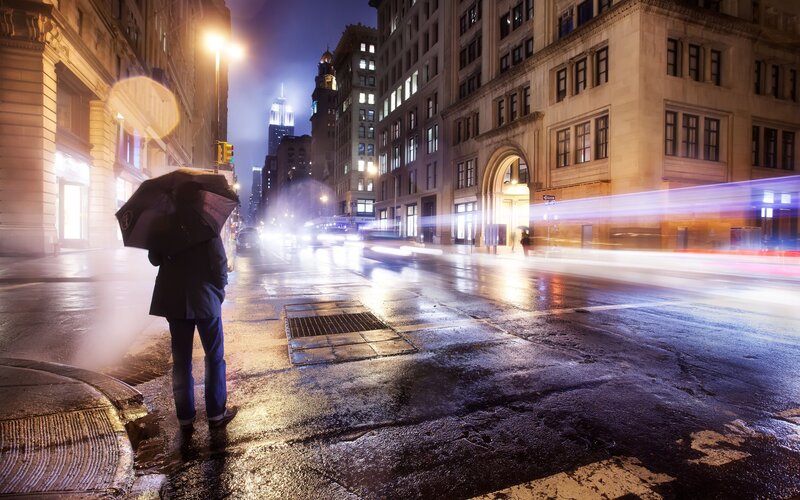 person with umbrella on rainy street
