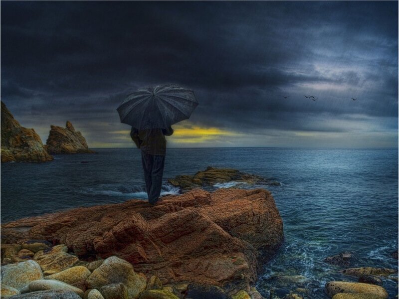 Person with Umbrella on Rocks