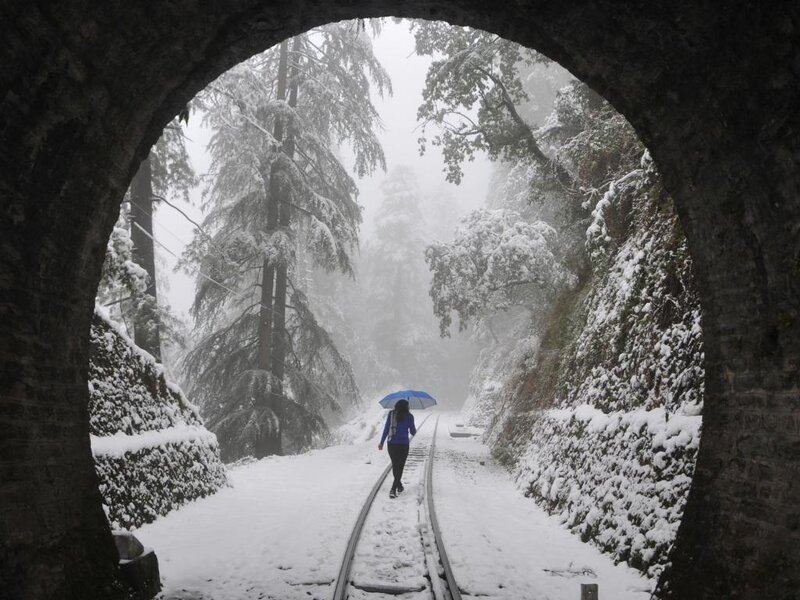 Person with Umbrella on Train Tracks