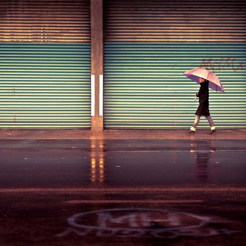 person with umbrella on wet street