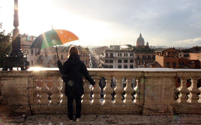Person with umbrella overlooking city