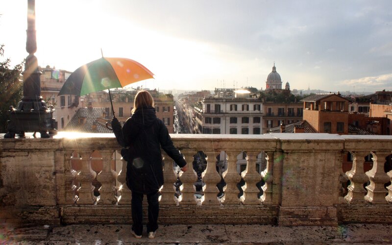 Person with umbrella overlooking city
