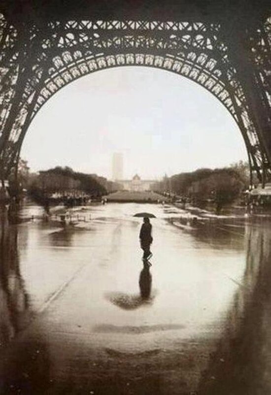 Person with umbrella under Eiffel Tower