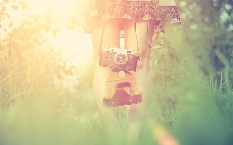 person with vintage camera in field