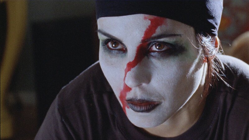 person with white face paint and red streak