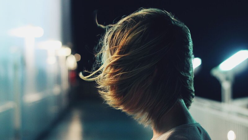 person with wind-blown hair at night