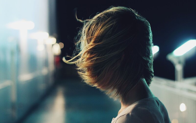 person with windblown hair at night