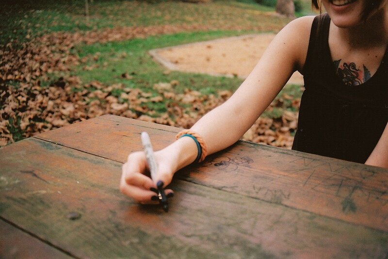 person writing on a wooden table