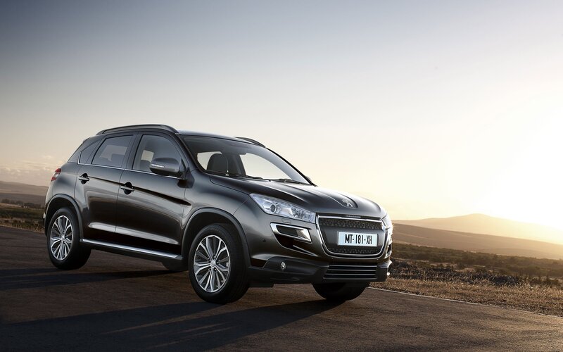 Peugeot SUV on a road at sunset