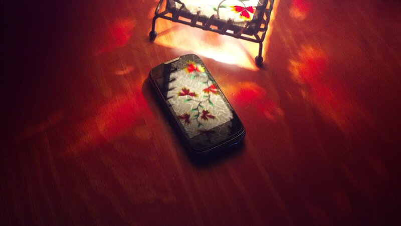 phone on wooden floor with light