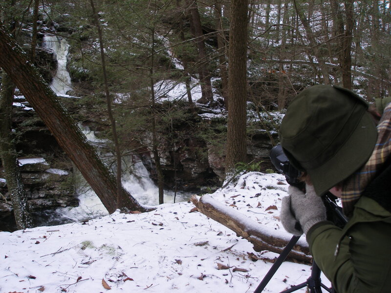 Photographer at snowy waterfall