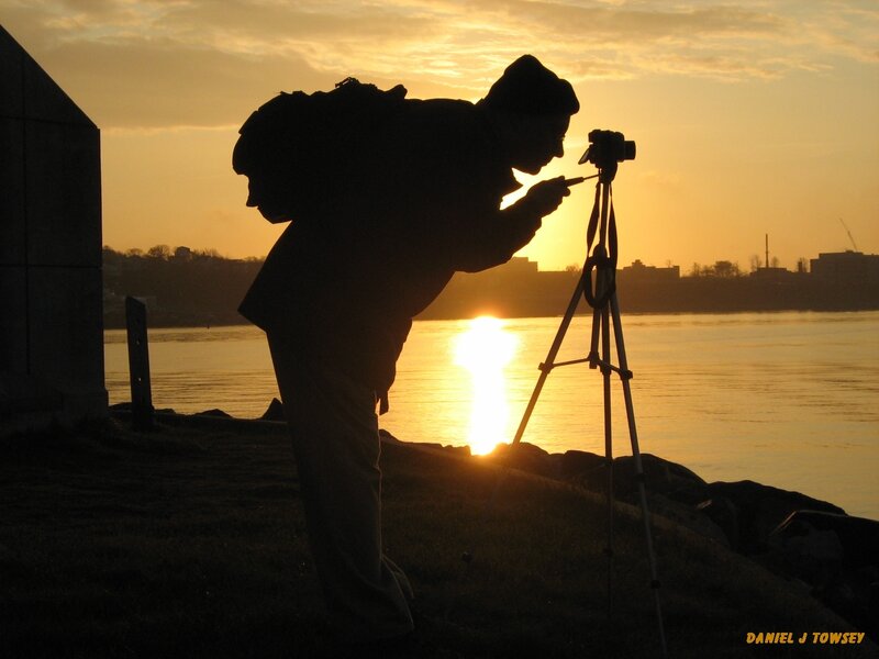 Photographer at sunset by water