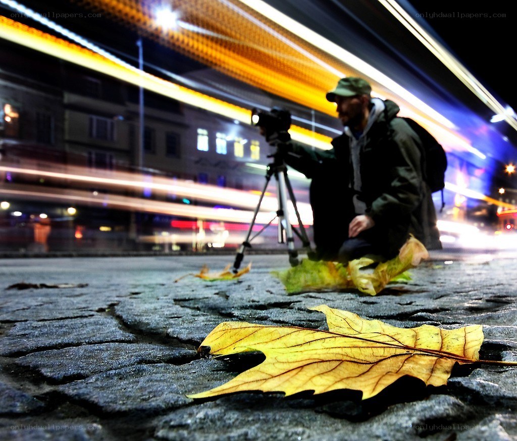 Photographer capturing light trails at night