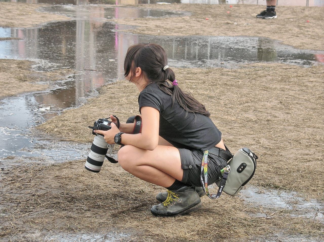 Photographer crouching in mud