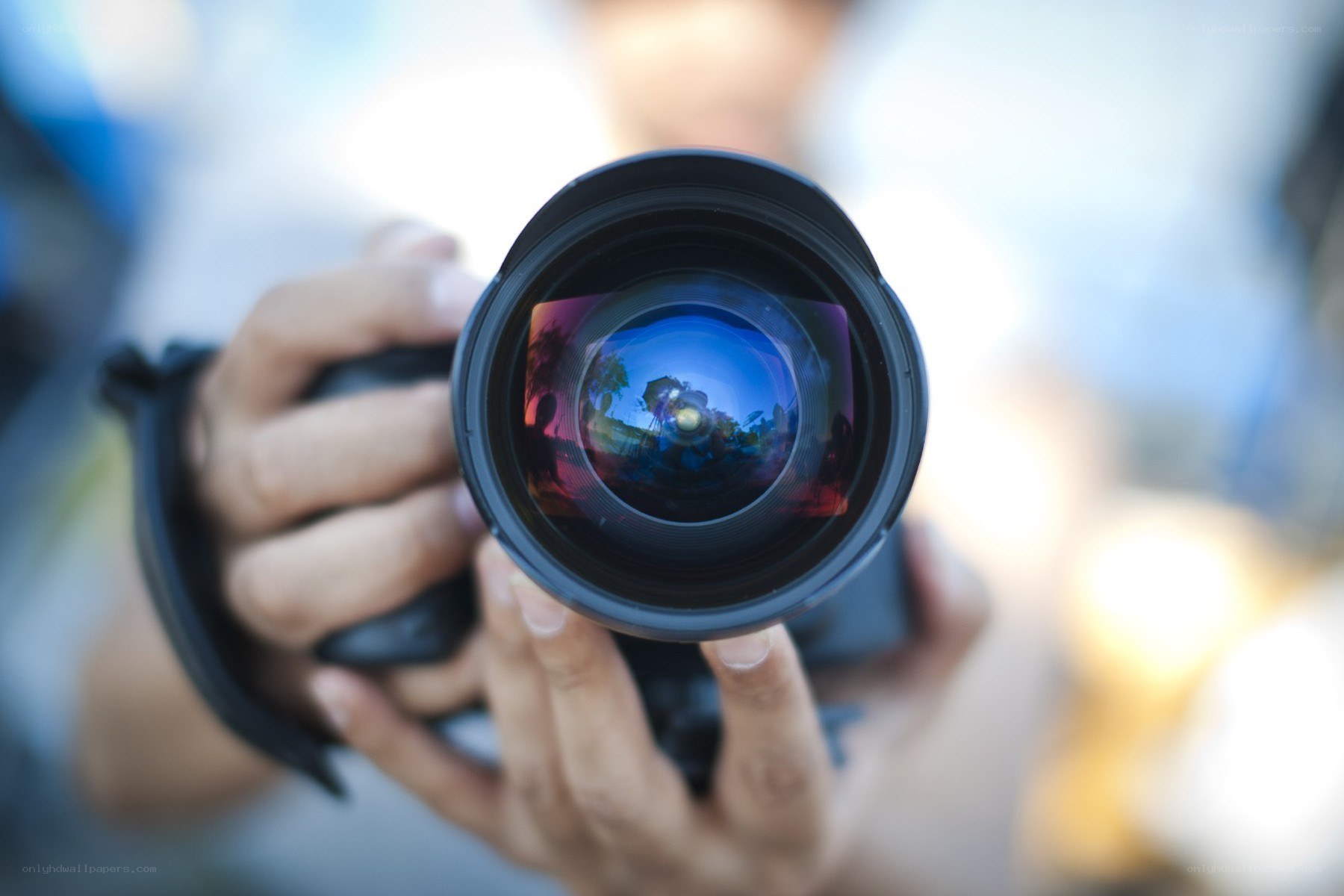 Photographer holding camera lens