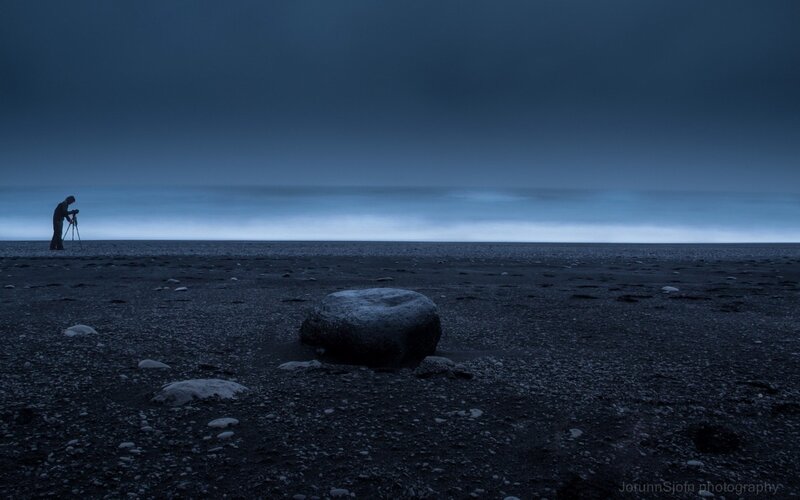 Photographer on a dark beach