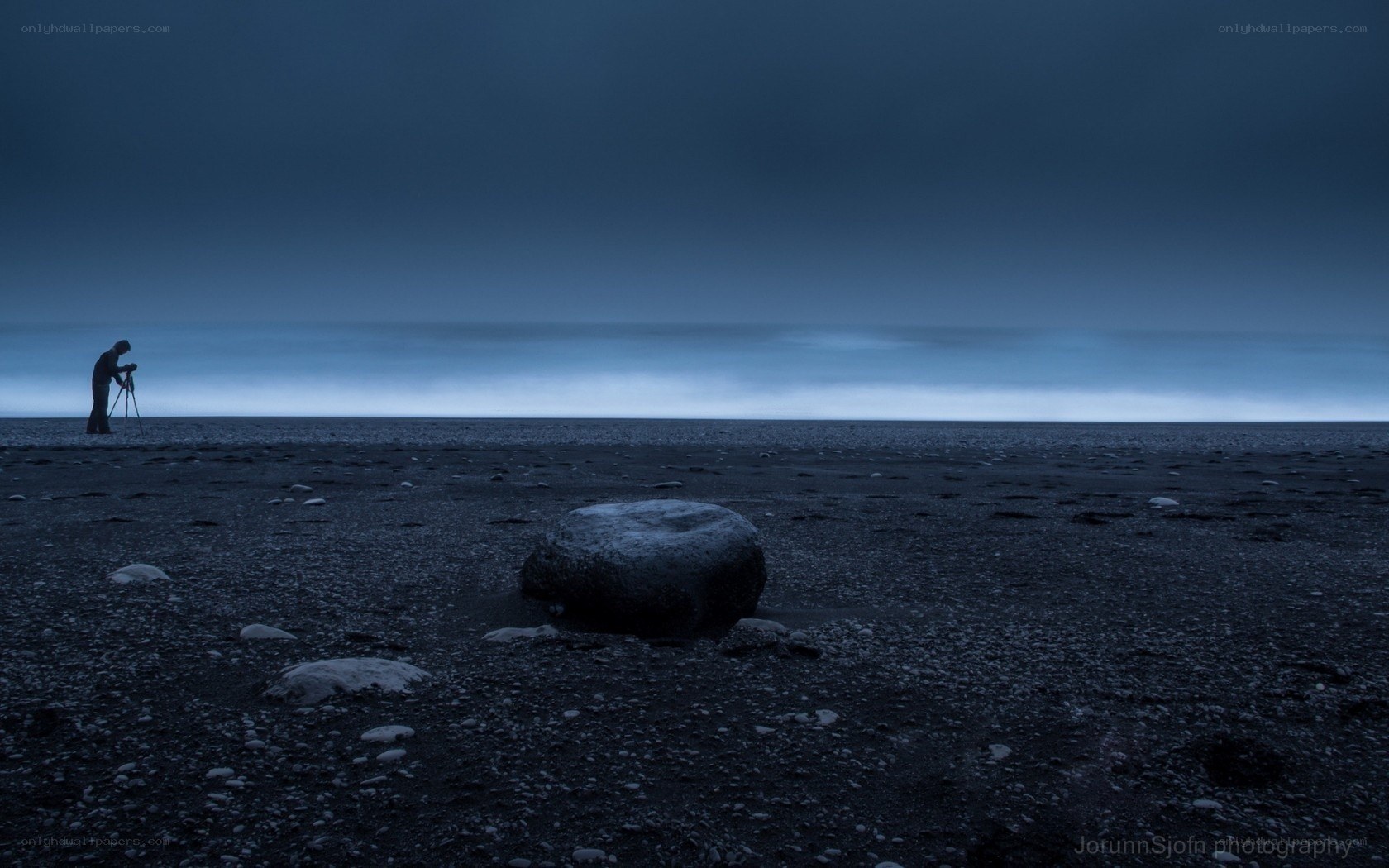 Photographer on a dark beach