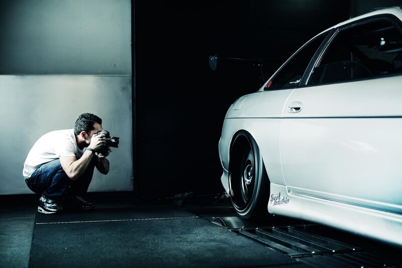 Photographer shooting a white car