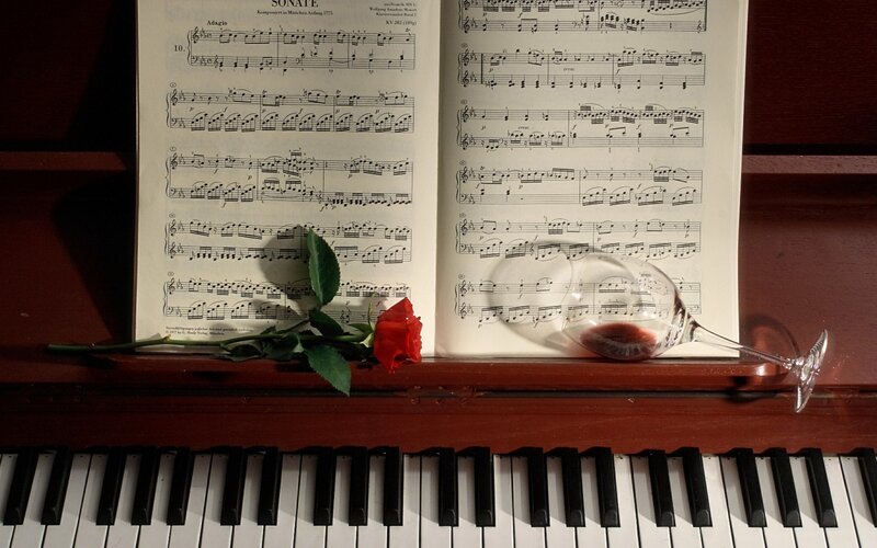 Piano sheet with rose and wine glass