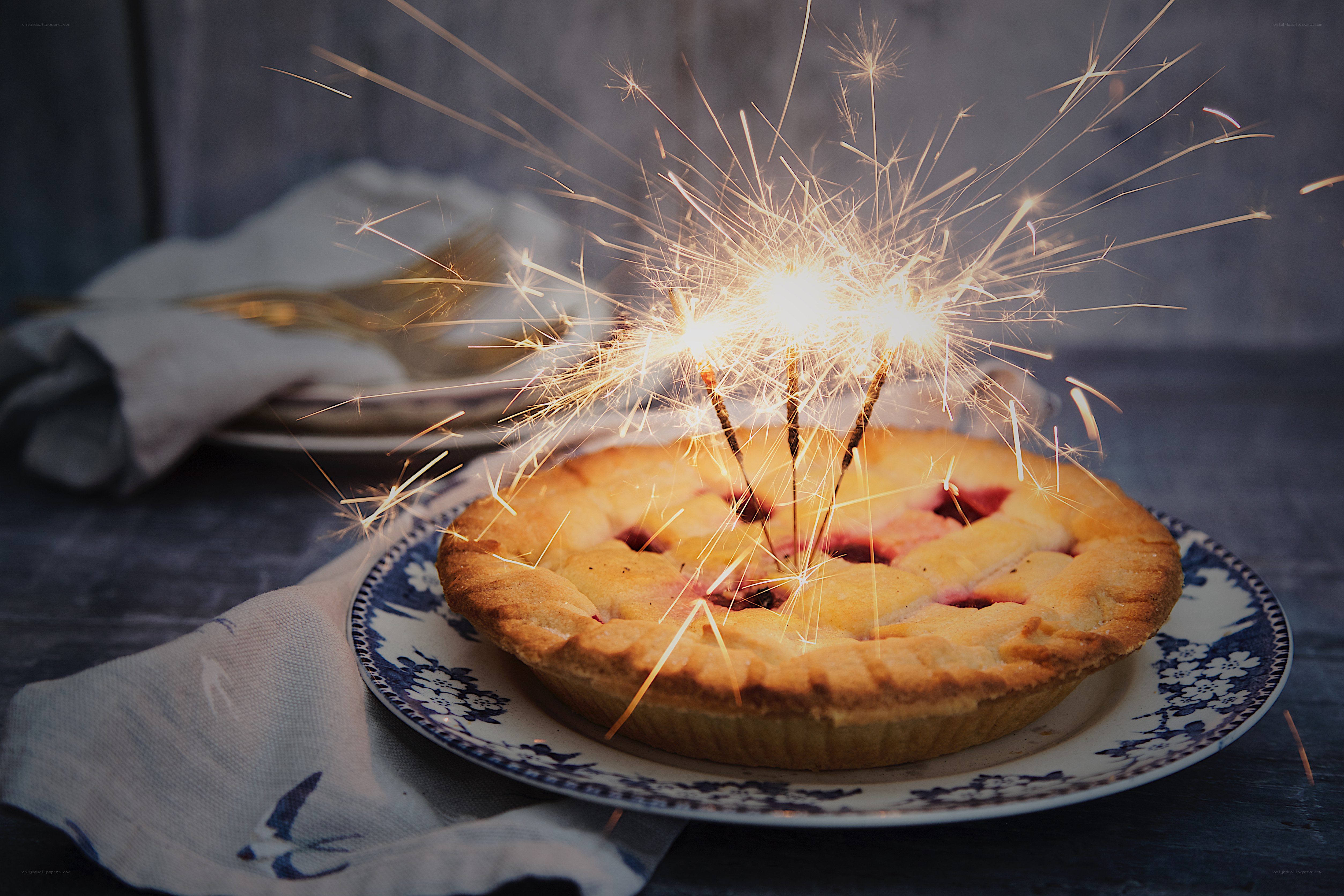Pie with sparklers on table