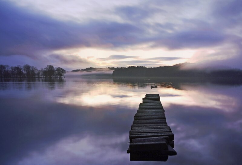 Pier at dawn on a misty lake