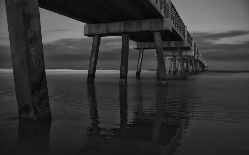 Pier at dusk in black and white