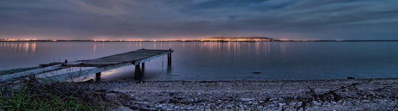 Pier at dusk with city lights