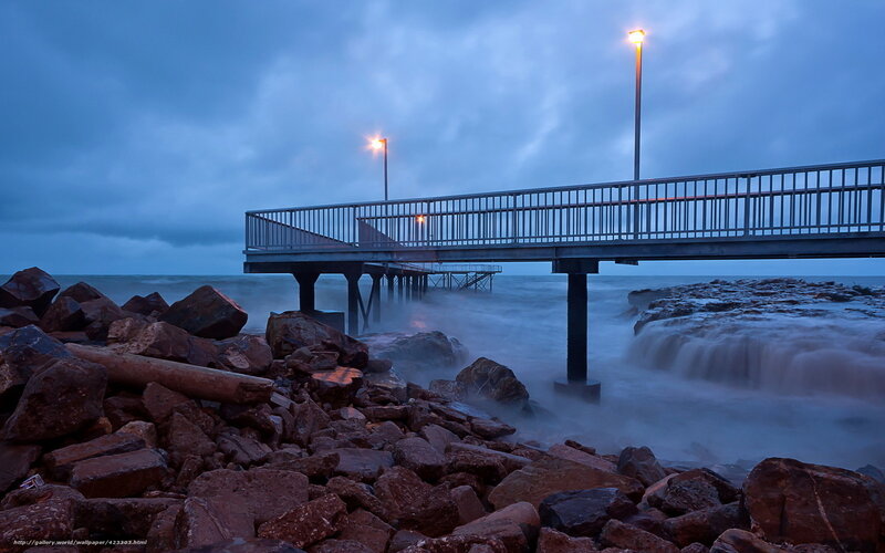 Pier at dusk with crashing waves