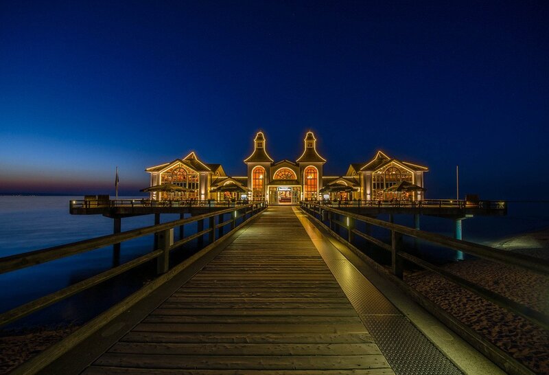 pier at dusk with illuminated buildings