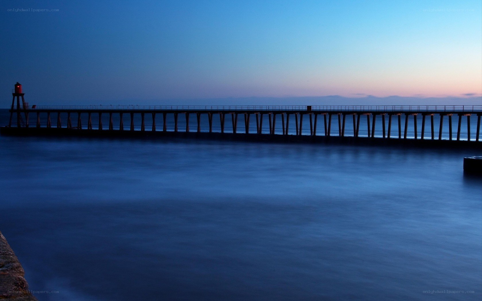 Pier at dusk with lighthouse
