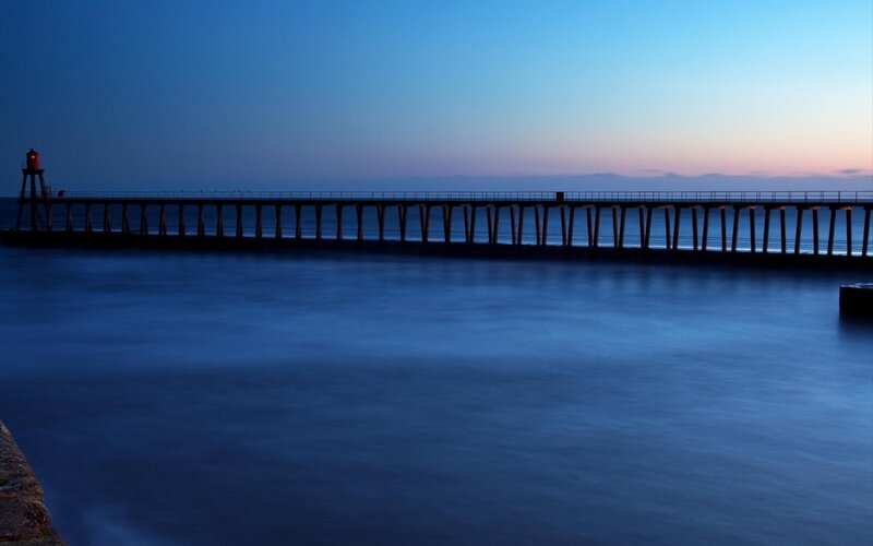 Pier at dusk with lighthouse