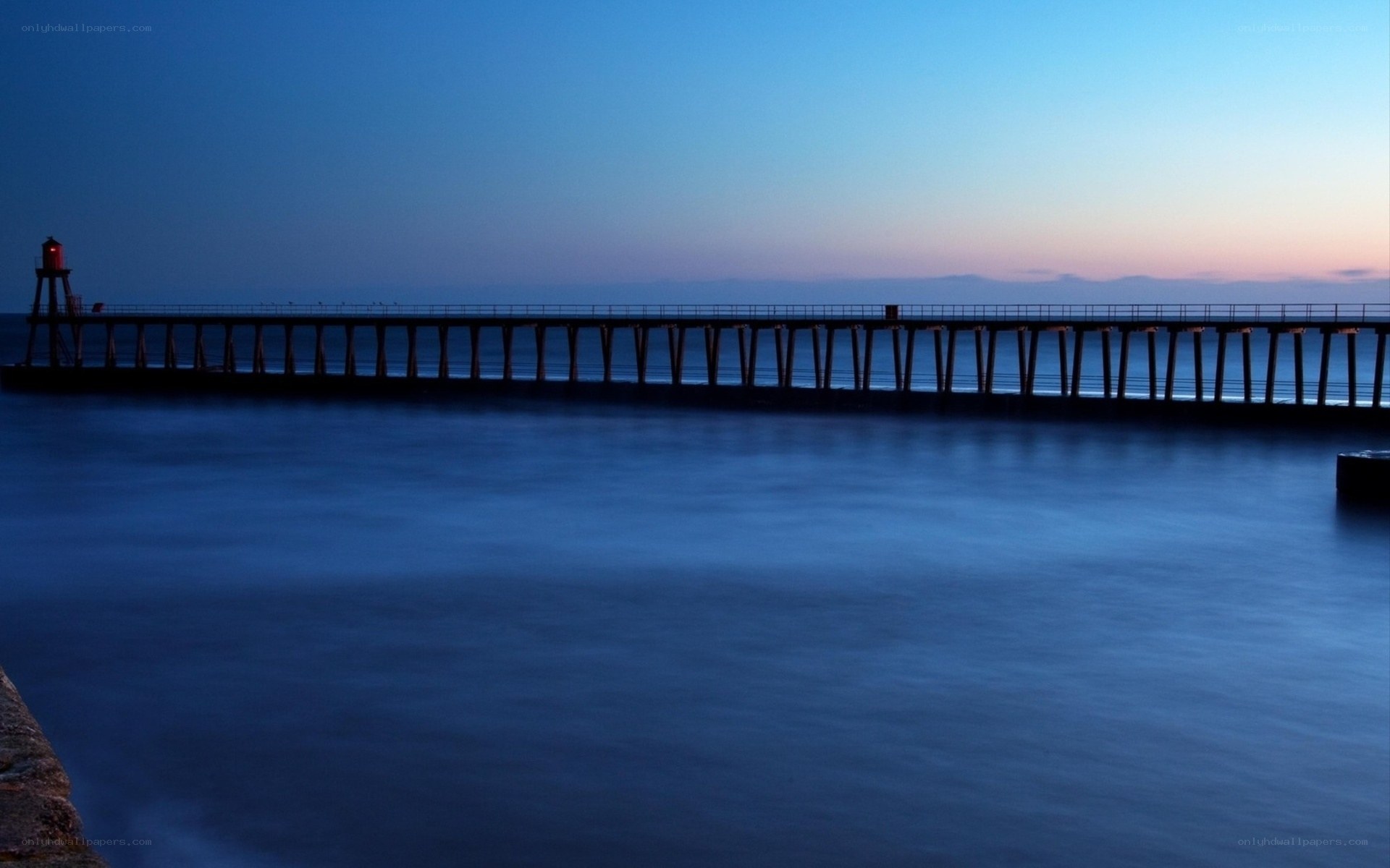 Pier at dusk with lighthouse